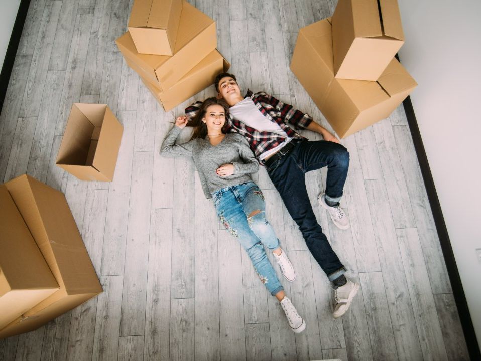 pareja tumbada en el suelo rodeados de cajas